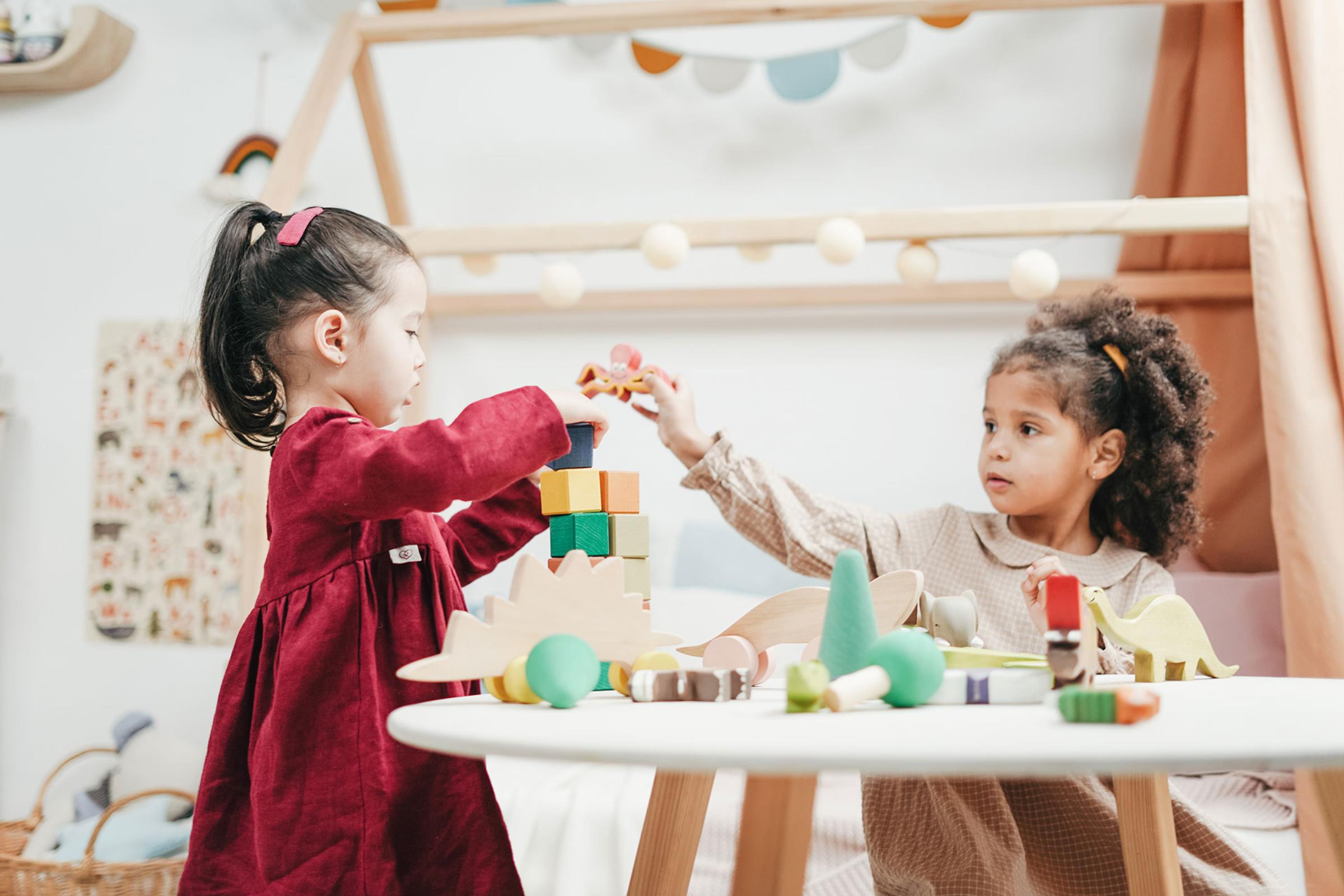 Two children playing with blocks at a child’s table
